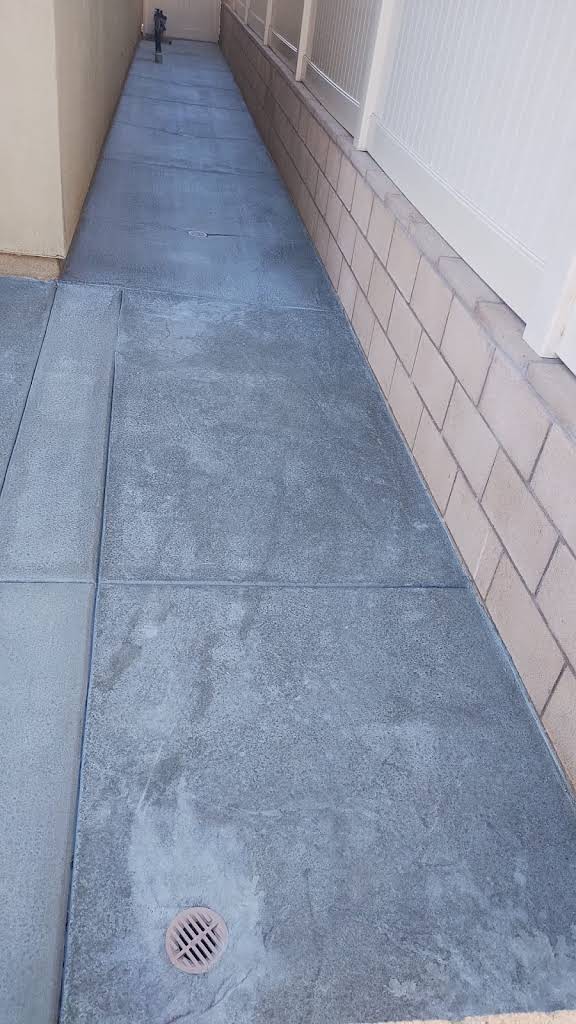 Narrow finished concrete walkway beside a home