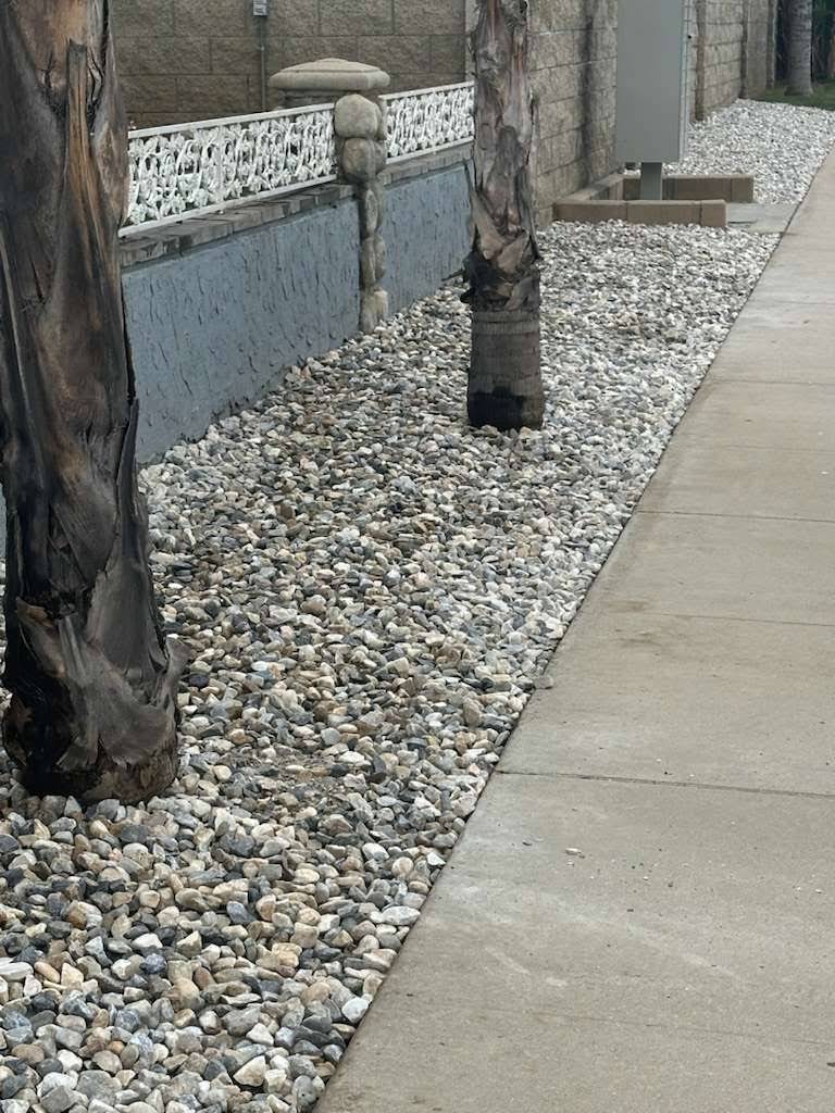 Decorative rock landscape bed beside a concrete walkway